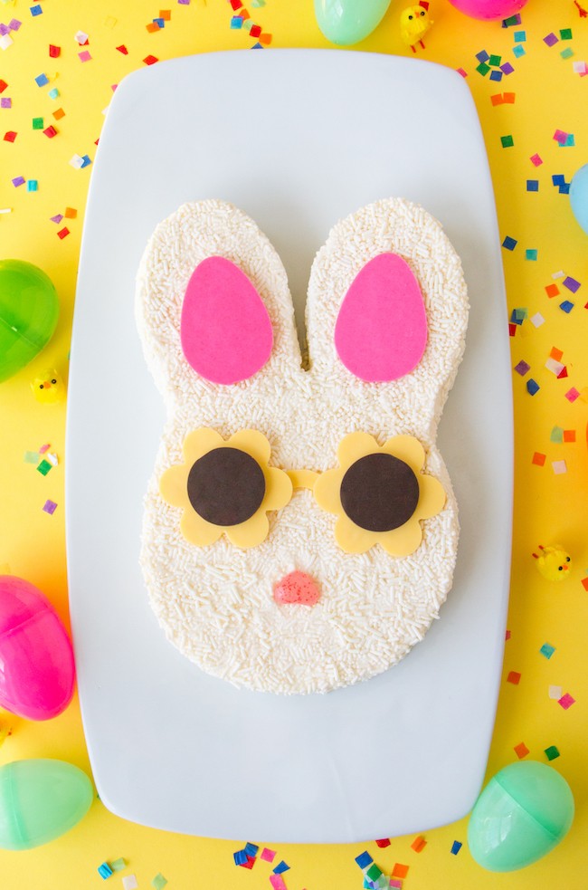 Bunny cake covered in white sprinkles with pink chocolate ears and yellow chocolate sunglasses | Erin Gardner | Erin Bakes