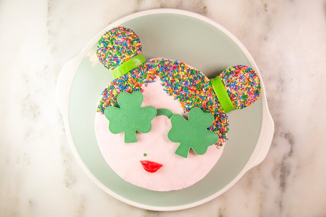 Round cake finished with buttercream, sprinkle hair, and shamrock-shaped green chocolate sunglasses | Erin Gardner | Erin Bakes